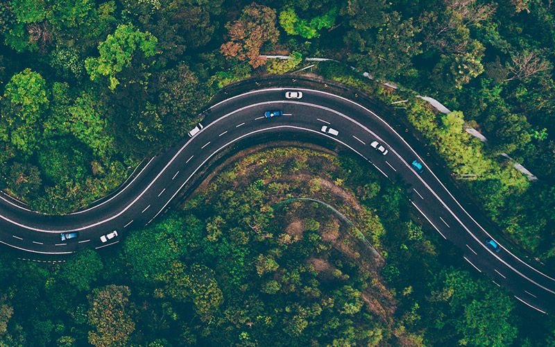 Aerial view of a winding road through a forest